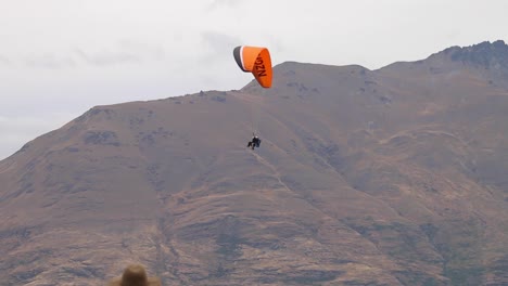 Gleitschirm-Schwebt-über-Queenstown-Mit-Berglandschaft-Im-Hintergrund