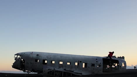 Abgestürztes-Flugzeug-In-Südisland-Außerhalb-Von-Vik-An-Einem-Schwarzen-Sandstrand-Bei-Sonnenuntergang-Und-Herunterspringen