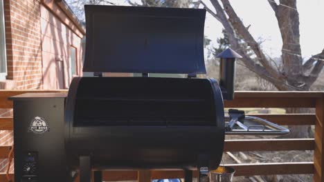 Smoke-coming-from-a-grill-while-warming-up-and-getting-ready-to-cook-on-a-wood-pellet-grill-during-the-evening