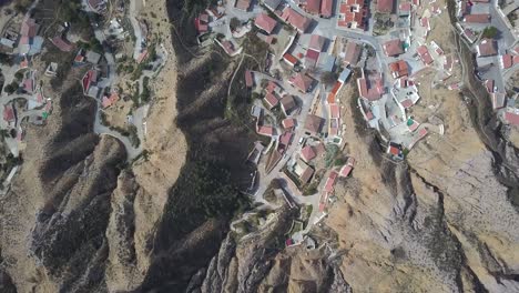 Overhead-aerial-view-of-an-old-spanish-town-close-to-a-big-mountain-in-the-desert