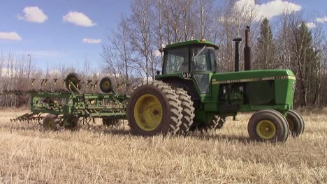 Tractor-with-a-cultivator-unfolding-it's-wings-to-till-a-field