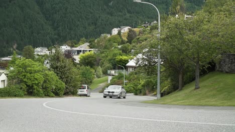 Luxury-car-BMW-730d-driving-uphill-through-Queenstown,-New-Zealand