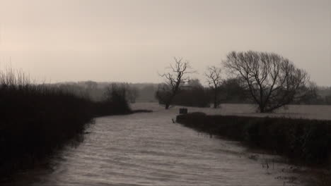 UK-February-2014---Rain-falls-on-a-flooded-country-road-with-submerged-hedges-and-trees-as-a-storm-passes-over