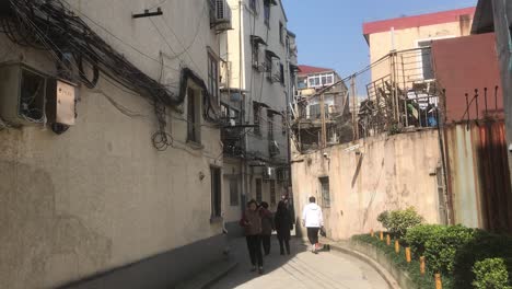 hand-held-shot-of-an-urban-genuine-musty-backyard-area-in-French-Concession,-Shanghai-on-a-sunny-blue-sky-spring-day