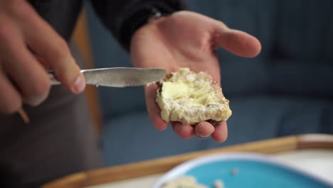 Slowmo---Kaukasischer-Mann-Verteilt-Butter-Auf-Frisch-Gebackenem-Traditionellen-Neuseeländischen-Scone