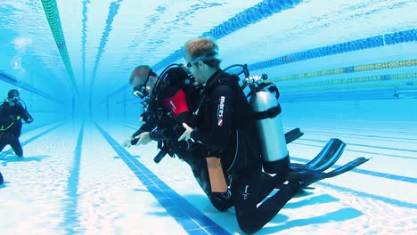 Dos-Instructores-De-Buceo-Demostrando-Procedimientos-De-Seguridad-A-Un-Grupo-De-Estudiantes