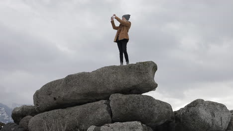 Una-Niña-Toma-Fotos-De-Las-Montañas-Nevadas-Que-La-Rodean