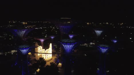 Fliegen-Und-Schwenken-Um-Giants-Mushroom-Konstruktion-Und-Singapore-Gardes-By-The-Bay-Bei-Nacht,-Wenn-Lichter-Leuchten-Und-Glühen---Drohnenaufnahme-Aus-Der-Luft