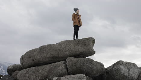 Ein-Mädchen-Steht-Auf-Felsbrocken-Und-Genießt-Die-Aussicht