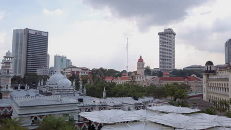 Pan-up-of-Masjid-Jamek-with-the-Sultan-Abdul-Samad-building-in-the-background,-Kuala-Lumpur,-Malaysia