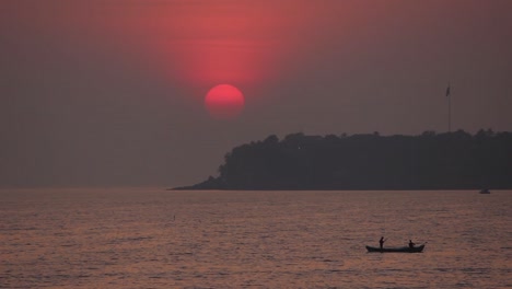 Beautiful-view-of-sunset-from-Mumbai-Marine-drive-with-a-small-fisherman-boat-and-a-island-silhouette-stock-video-I-Sunset-view-stock-video-in-Full-HD