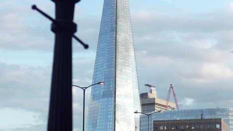 Plane-flying-beside-The-Shard-building-in-London,-England-on-a-cloudy-day