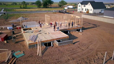 Ein-Drohnenschuss-Drückt-Langsam-Auf-Bauunternehmer,-Die-Wände-Für-Ein-Neues-Haus-Aufstellen,-Das-Gerade-Gebaut-Wird