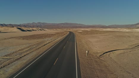 Low-aerial-view-along-an-empty-highway-in-the-desert