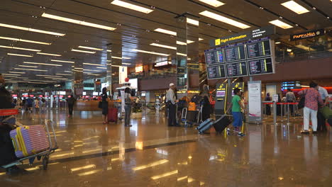 Singapore---Circa-time-lapse-zoom-out-shot-locked-position-of-busy-Singapore-Changi-International-Airport-indoor-terminal,-many-passengers-departing-and-arriving,indoor-daytime-lots-of-people