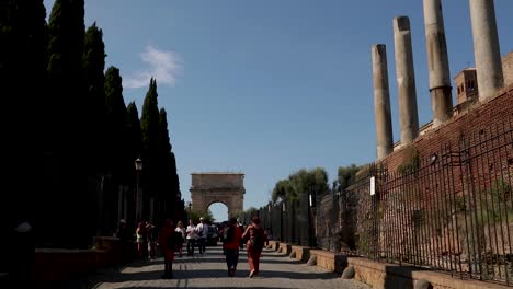 Panning-shot-of-tourists-roaming-around-the-Colosseum-in-Rome,-Italy