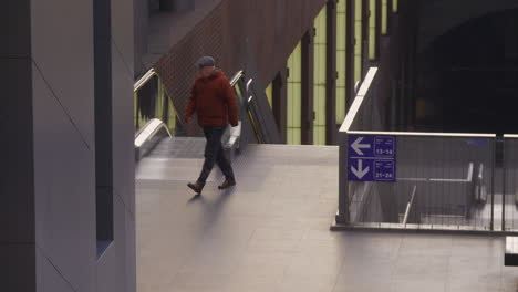 Un-Hombre-Que-Viene-De-Las-Escaleras-Mecánicas,-Caminando-Hacia-Una-Plataforma-De-Tren-Diferente-En-La-Estación-Central-De-Antwerp
