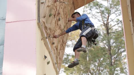 Fitness,-Deporte-Extremo,-Boulder-Al-Aire-Libre,-Gente-Y-Concepto-De-Estilo-De-Vida-Saludable---Joven-Haciendo-Ejercicio-En-La-Pared-Del-Gimnasio-De-Escalada-Interior