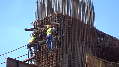 Bauarbeiter,-Die-In-Der-Höhe-Arbeiten-Und-Auf-Der-Baustelle-Stahlbewehrungsstäbe-Herstellen