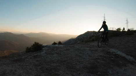 Mädchen,-Die-Bei-Sonnenuntergang-Auf-Dem-Gipfel-Eines-Berges-Fahrrad-Fahren
