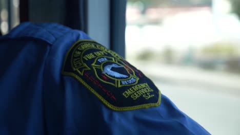 Patch-on-a-firefighter-uniform-seen-beside-the-window-of-a-driving-fire-truck