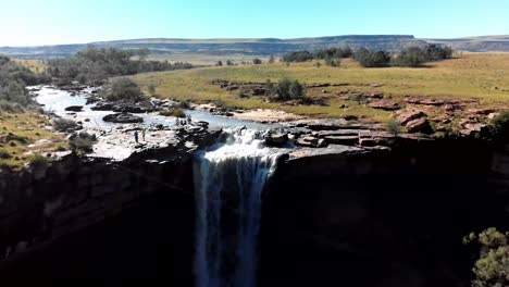Aerial-footage-of-a-sunny-summer-day-with-a-waterfall