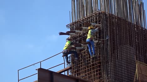 Construction-workers-working-at-height-fabricating-steel-reinforcement-bar-at-the-construction-site