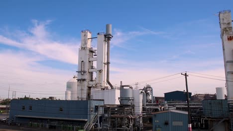 Industrial-unmarked-building-with-clouds-rolling-by-in-the-background-on-a-blue-and-sunny-day