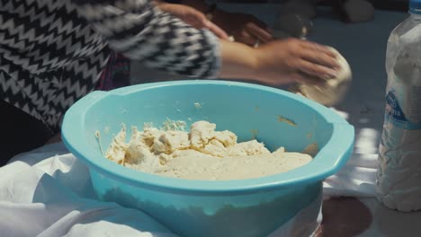 Mujer-Refugiada-Afgana-Preparando-Masa-Para-Hornear-Pan-En-Un-Horno-Tandoor-Tradicional-Autoconstruido-En-Un-Campamento-De-Refugiados