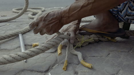 Old-Vietnamese-man-working-braiding-ropes-for-use-on-river-boats