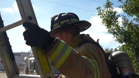 Firefighter-climbing-up-a-ladder-during-an-emergency-response-and-rescue-operation