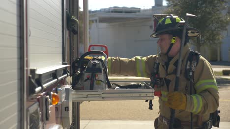 Firefighters-pull-a-rescue-saw-out-of-a-fire-truck-to-respond-to-a-fire