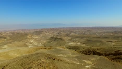 Aerial:-Above-Yellow-dry-Desert-with-Blue-Sky