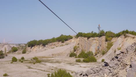 A-young-man-glides-through-an-old-rock-quarry-on-a-zip-line