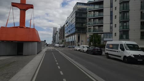 Radfahren-In-Den-Docklands-Von-Dublin-Mit-Gebäuden-Auf-Der-Rechten-Seite,-Flüssiges-Filmmaterial