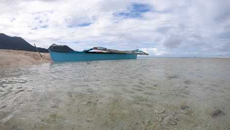 Nahaufnahme-Eines-Kleinen-Blauen-Bootes-Im-Ozean-In-Der-Nähe-Eines-Sandigen-Tropischen-Strandes-Und-Eines-Weißen-Bewölkten-Himmels-Philippinen-4k