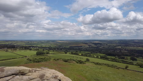 Left-to-Right-Pan-of-the-Rural-View-from-the-top-of-Almscliffe-Crag-in-North-Yorkshire-on-a-Summer’s-Day-with-Blue-Sky---White-Clouds