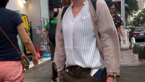 Japanese-Shoppers-Walking-Along-the-Sidewalk-at-Popular-Shopping-Street,-Kokusai-Dori,-Naha,-Okinawa