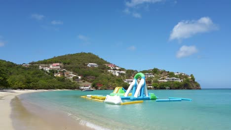 A-bouncy-castle-set-up-on-an-epic-crystal-clear-water-beach-in-Mourne-Rouge,-Grenada