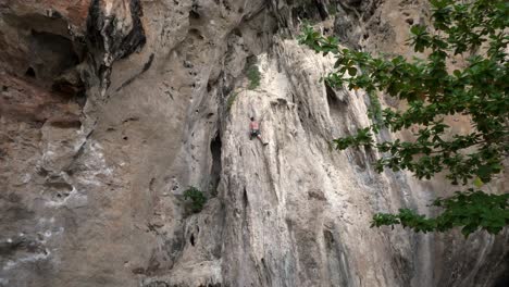 Young-travelers-with-a-rope-engaged-in-the-sports-of-rock-climbing-on-the-rock-at-Krabi-in-Thailand