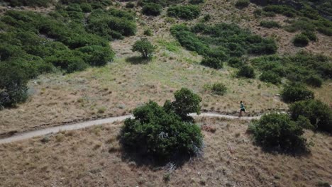 Drone-Shot-following-an-active-man-running-on-the-outdoor-Wasatch-Mountain-trails-above-Draper-City,-Utah
