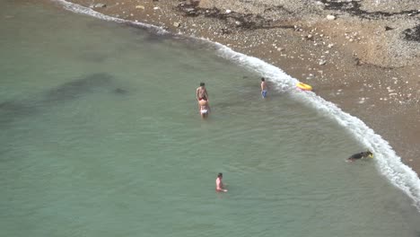 Blick-Von-Oben-Auf-Einige-Menschen,-Die-Im-Kalten-Wasser-Des-Meeres-Schwimmen