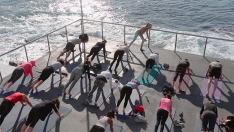 A-early-morning-outdoor-group-yoga-class-at-Bondi-Beach-next-to-the-ocean