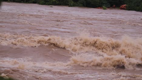Dorf,-Bäume-Und-Kleine-Hügel,-Die-Aufgrund-Starker-Regenfälle-Von-Überschwemmungen-überschwemmt-Wurden-Und-Einen-Starken-Wasserfluss-Aus-Dem-Stausee-In-Nord-Karnataka,-Indien,-Verursachten