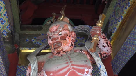 Statue-of-an-old-wooden-god-with-evil-look-in-the-Toshogu-Shrine-temple-in-Nikko,-Japan