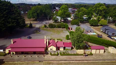 Reverse-and-rising-drone-footage-of-the-railway-station-and-township-of-Trentham,-Victoria,-Australia