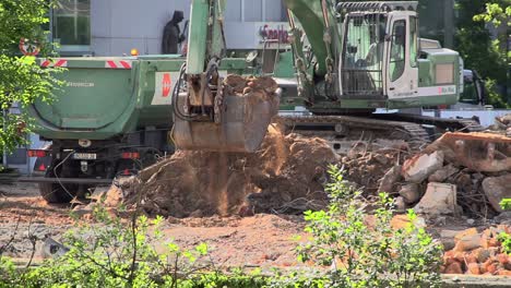 Großer-Bagger,-Der-Schmutz-Und-Schutt-Von-Hand-Auf-Einen-LKW-Lädt