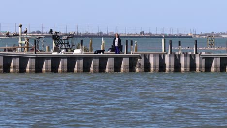 Mujer-Esperando-Pacientemente-En-El-Embarcadero-En-La-Rampa-Para-Botes-Bajo-La-Calzada-Jfk