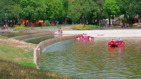 Városligeti-Lake-City-park,-the-other-side-of-the-park,-people-on-paddling-boats-and-walking-by