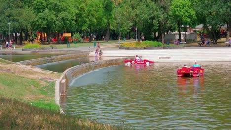 Parque-De-La-Ciudad-Del-Lago-Városligeti,-Al-Otro-Lado-Del-Parque,-Gente-En-Botes-De-Remo-Y-Caminando